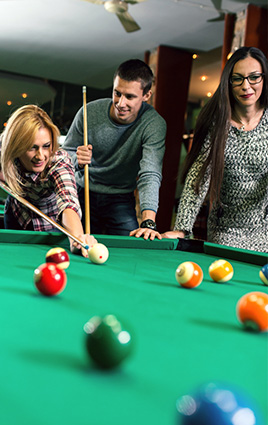 three people playing pool